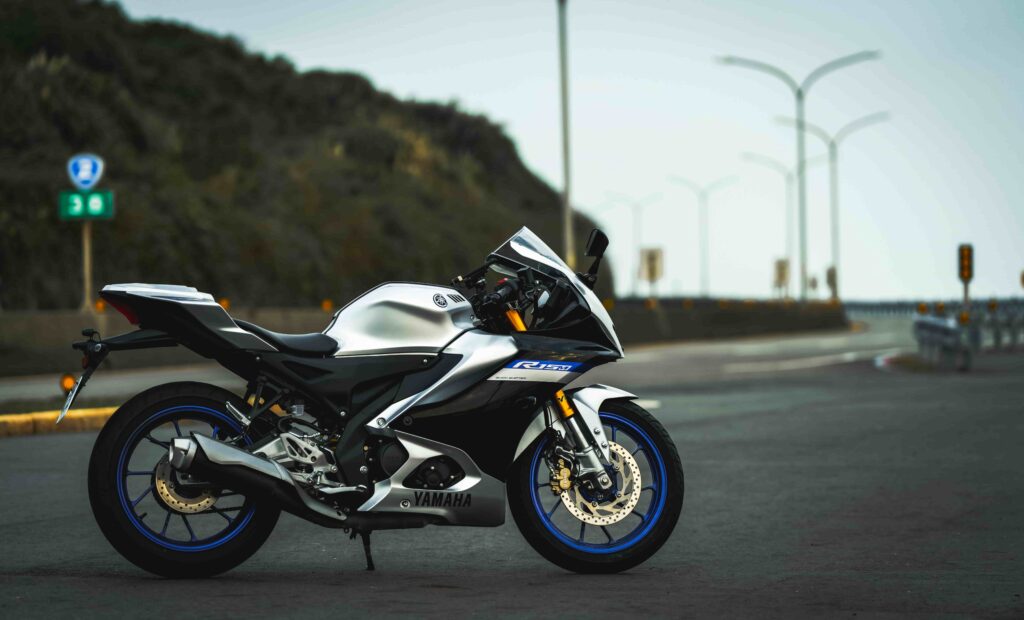 Yamaha sportmotor geparkeerd op een lege weg met berg en straatlantaarns op de achtergrond.