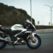Yamaha sportmotor geparkeerd op een lege weg met berg en straatlantaarns op de achtergrond.
