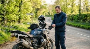 Motorrijder trekt handschoenen aan naast motor op rustige weg in de lente