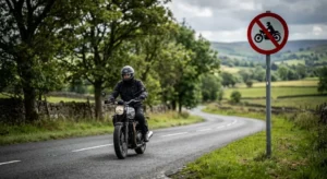 Motorrijder op landelijke weg met verkeersbord dat motoren verbiedt