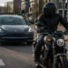 Motorrijder naast Tesla auto in verkeer met focus op veiligheid en herkenning